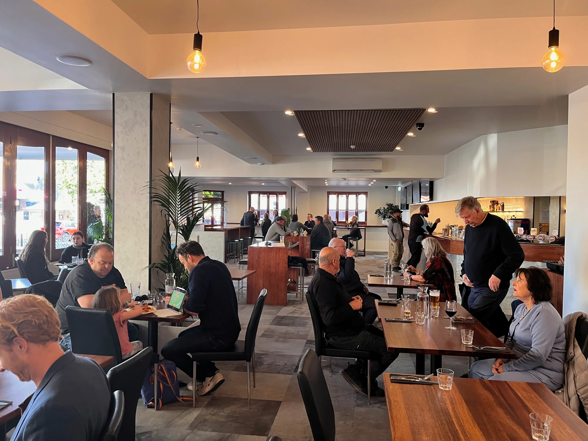 Guests enjoying drinks and conversation around the Queen’s Head Hotel bar